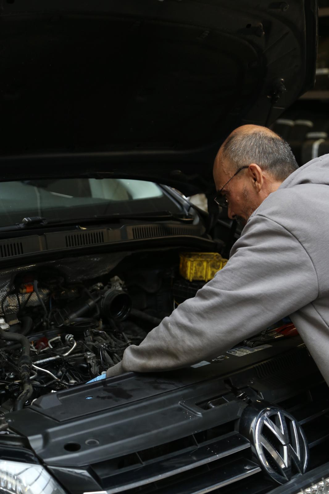 Mekaniker som utför service under motorhuven på en bil